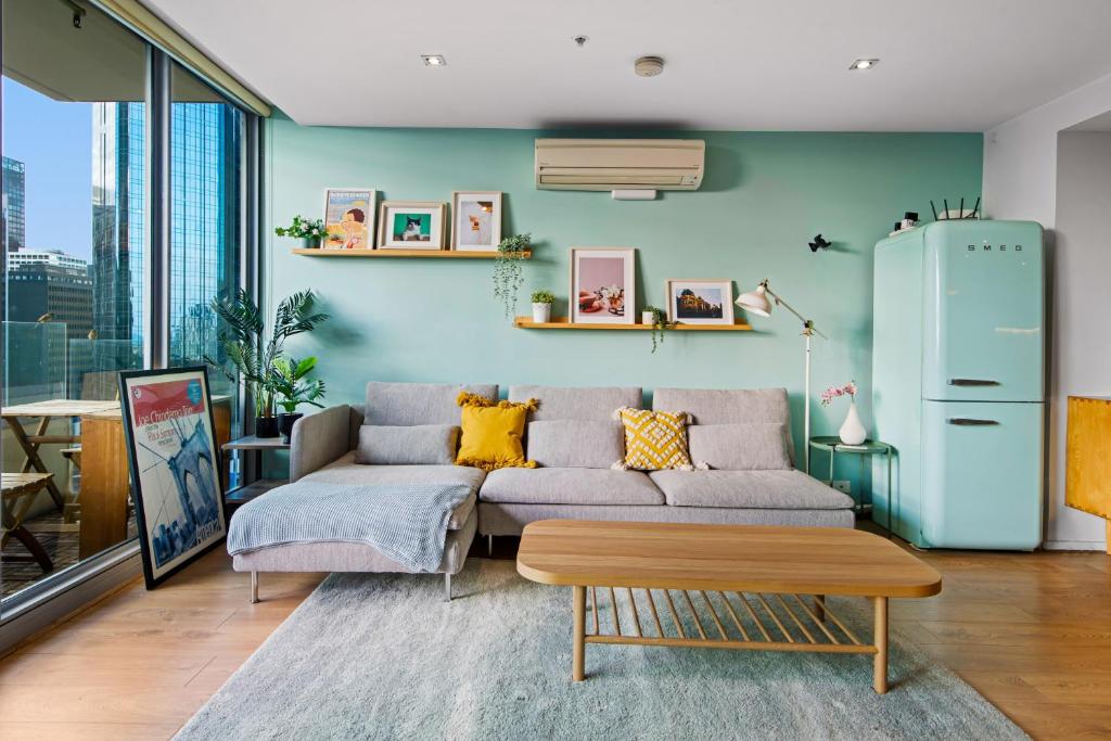 ein Wohnzimmer mit einem Sofa und einem Tisch in der Unterkunft Delightful City 2Bed with Home Theatre, Gym & Pool in Melbourne