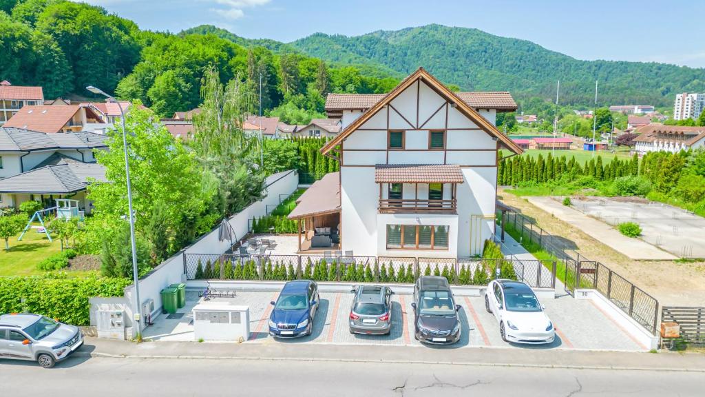 a group of cars parked in a parking lot in front of a house at Jungle Family Villa near Park Aventura,Lake,Zoo in Braşov