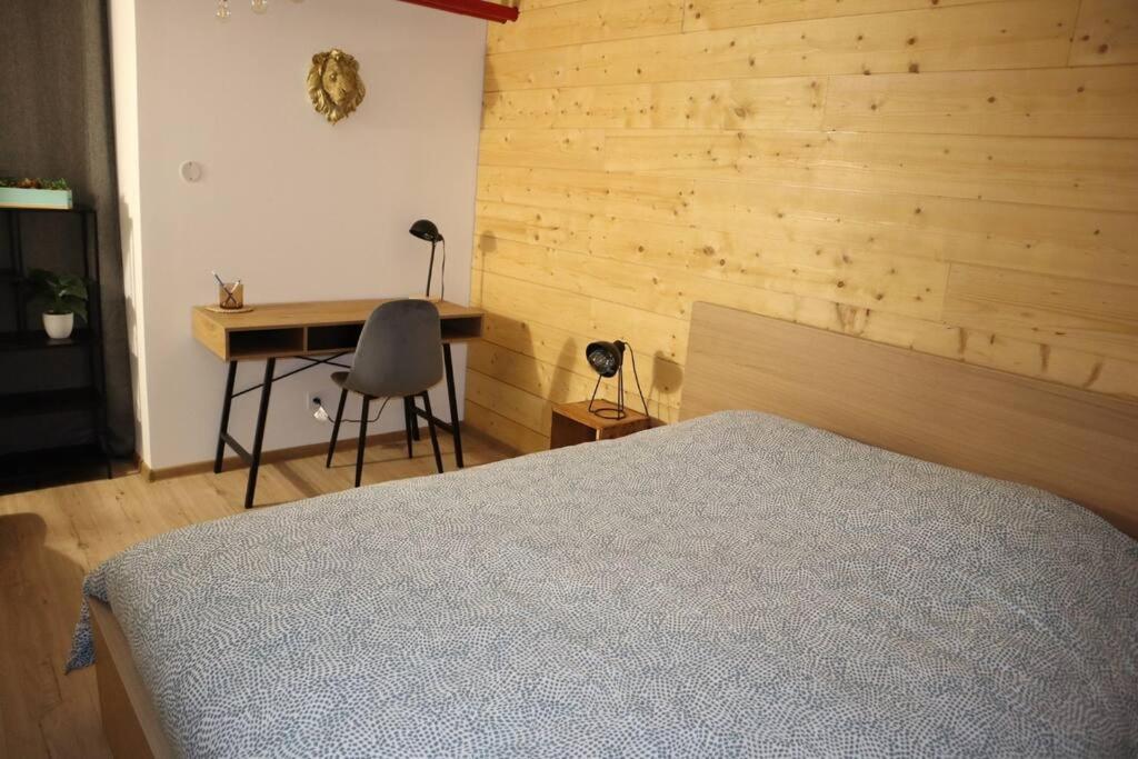a bedroom with a bed and a desk with a chair at Le petit Gambetta in Belfort