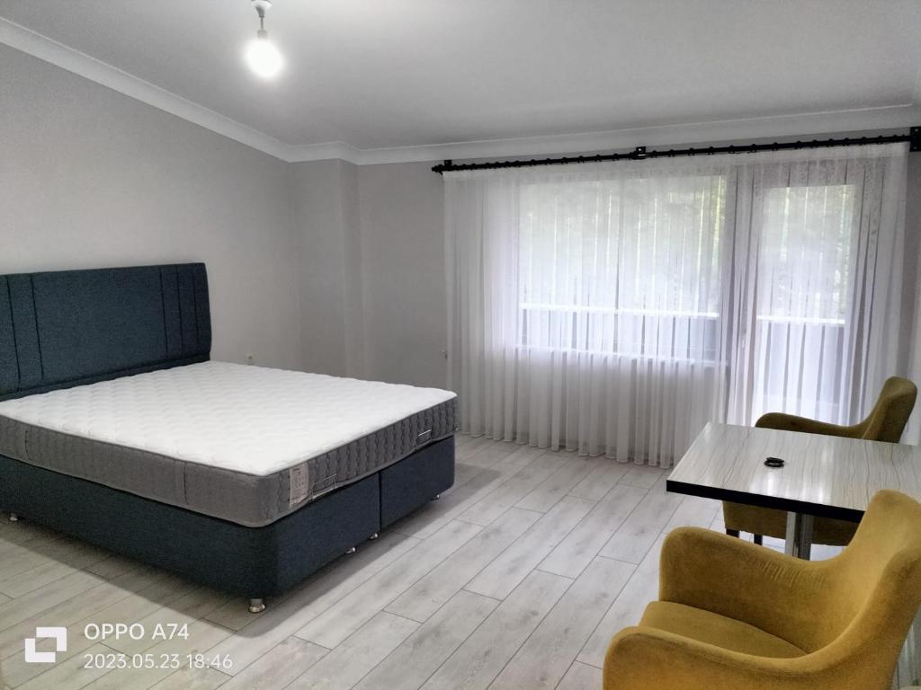 a bedroom with a bed and a table and chairs at TRABZON-AKÇAABAT/MERSİN in Vartara