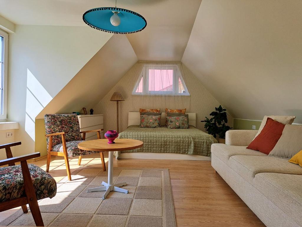 a attic room with a bed and a couch at Sadama Stay in Haapsalu