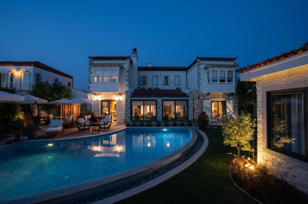 a large house with a swimming pool at night at Sedirli Ev in Alaçatı