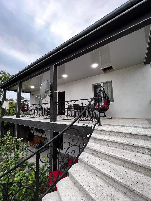 a balcony of a house with glass doors and stairs at Family Hotel Keti in Kobuleti
