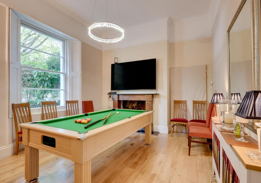 a living room with a pool table and a tv at Rutland Lodge Wellswood Mews in Torquay