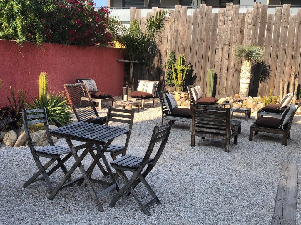 een groep stoelen en tafels in een tuin bij Hôtel Les Mimosas in Argelès-sur-Mer