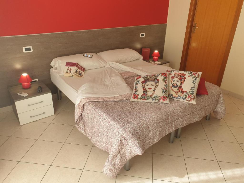 a bed with two pillows on it in a bedroom at Le Casette in Santa Flavia