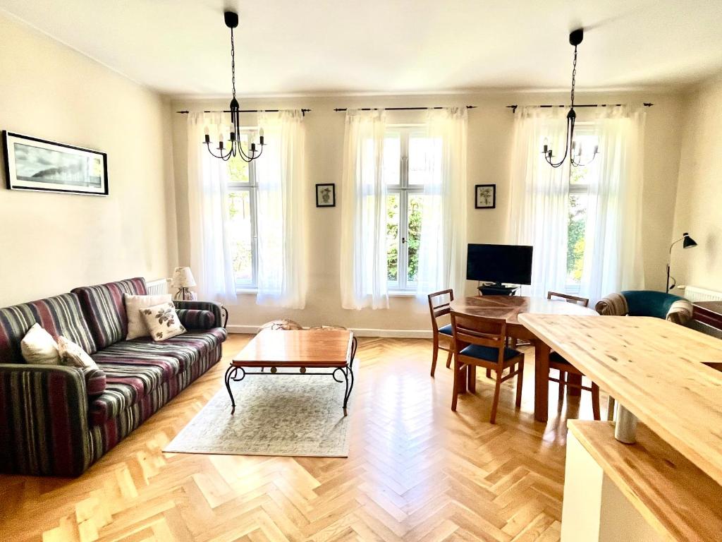 een woonkamer met een bank en een tafel bij Agapella Apartamenty- Apartament Helska 3 - 250m form the beach in Sopot