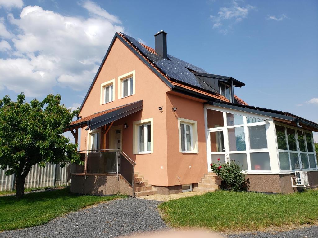 una casa con techo de gambrel en Berkenye Pihenőház en Sárvár
