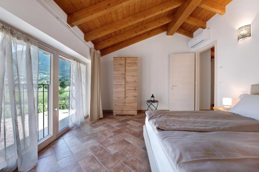 una camera con un letto e una grande finestra di Casale la Coccinella Gelsomino a Caprino Veronese
