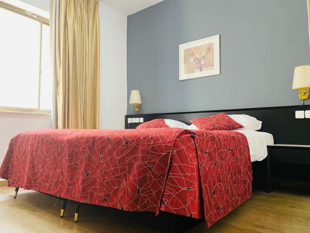um quarto com uma cama com um edredão vermelho em Apartment in Lev Jerusalem Hotel em Jerusalém