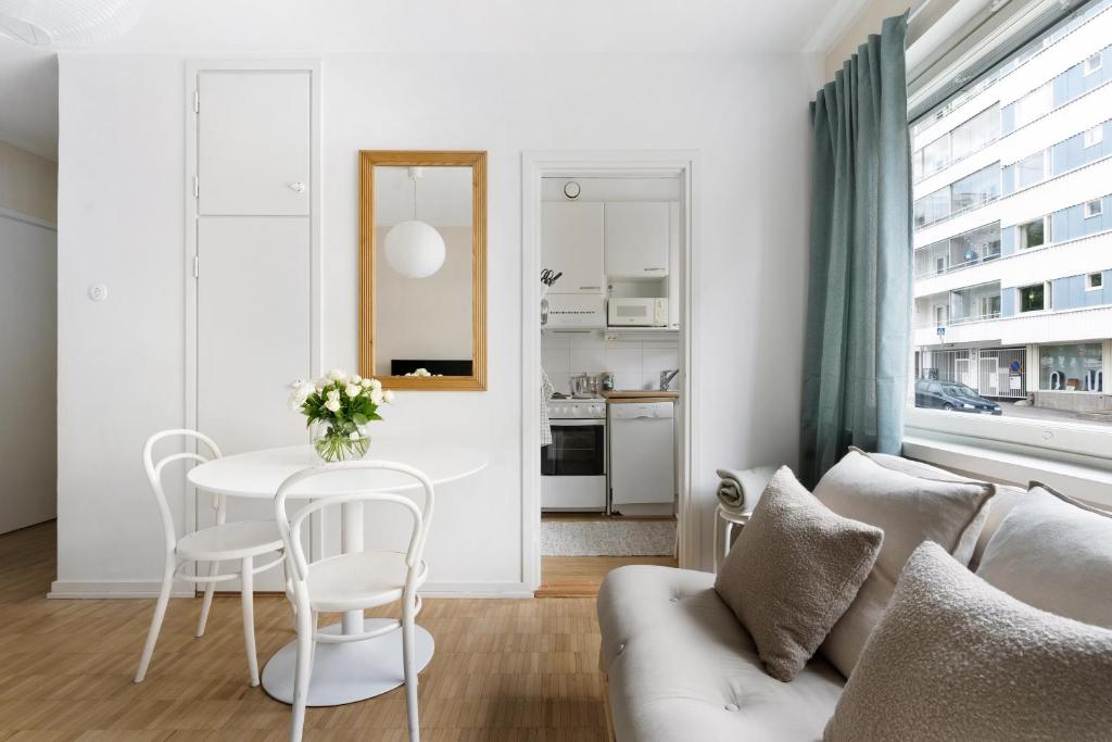 a living room with a white couch and a table at Stylish Nordic Studio by Tram Stop in Helsinki