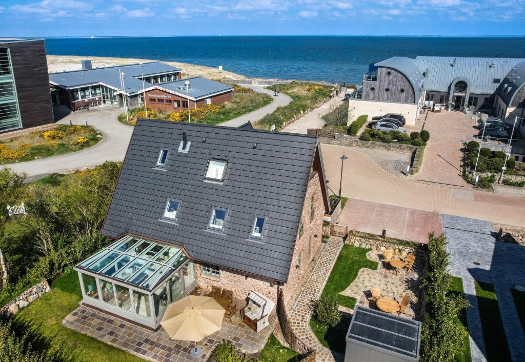an aerial view of a house with the ocean in the background at Strand und Meer in List