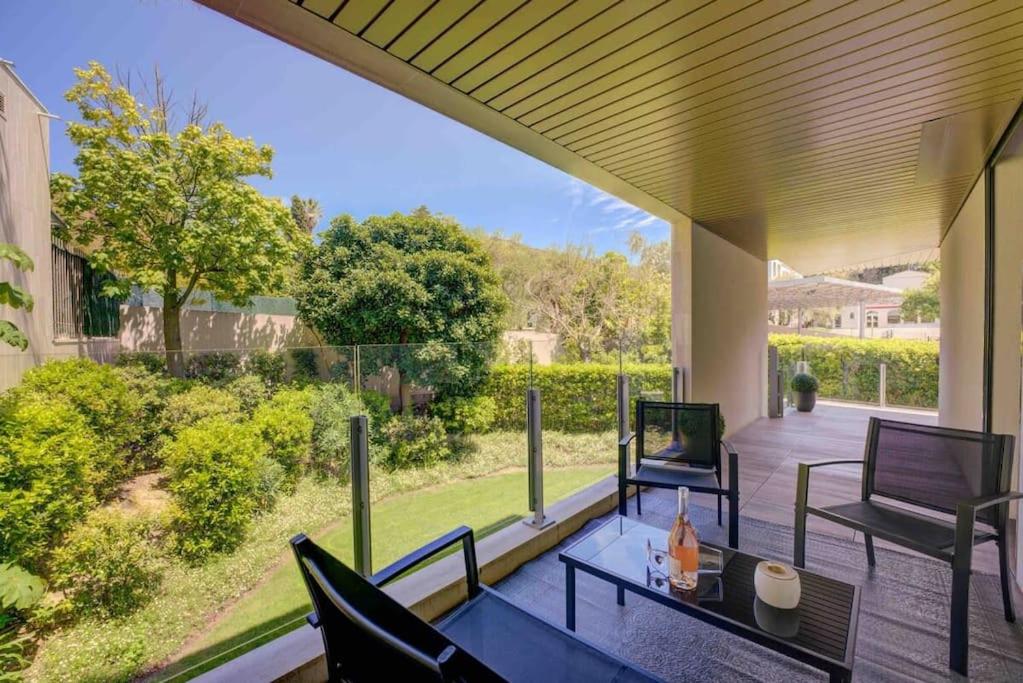 un patio avec une table et des chaises sur un porche dans l'établissement Stylish 1BDR Apt w/Huge Balcony/Shared Roof Pool, à Cannes