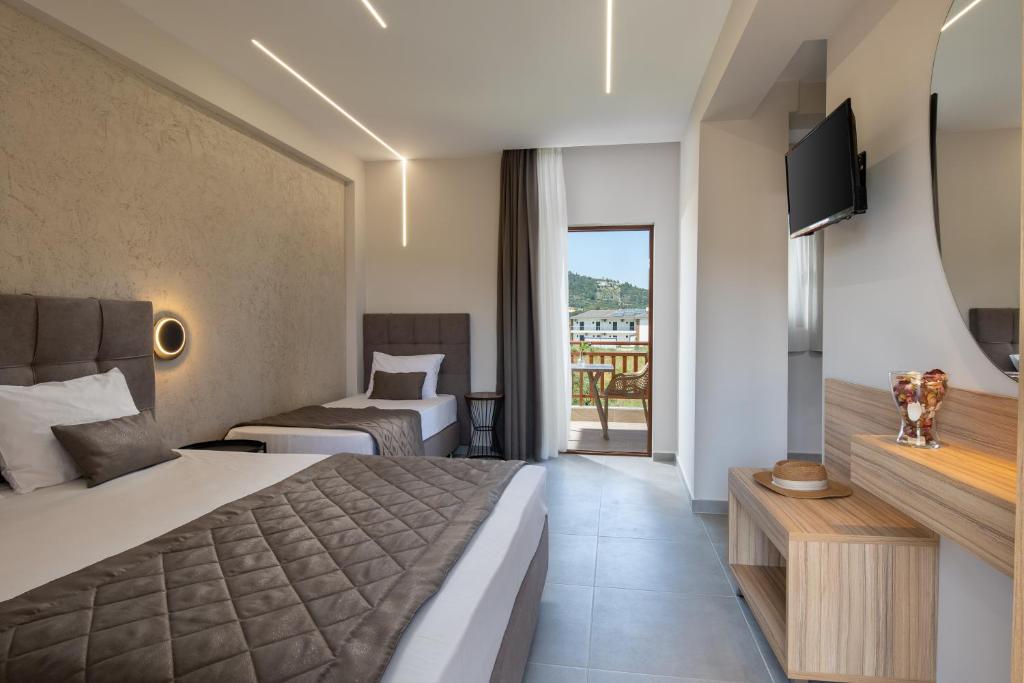 a hotel room with two beds and a television at Rodon Garden in Sarti