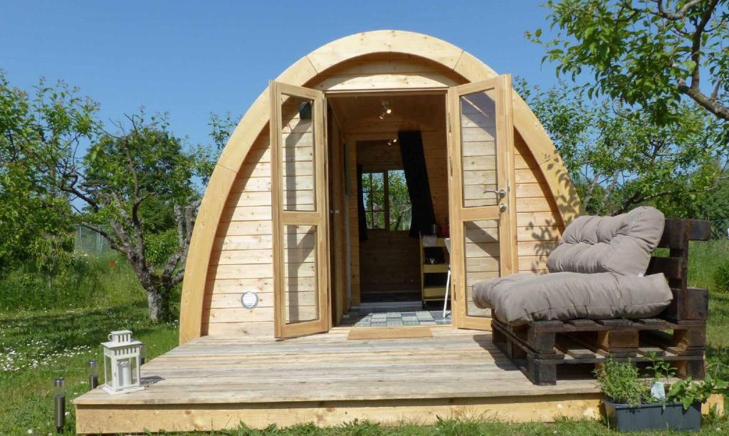 a small wooden house with an archway on a deck at B2B Campingpods Volkach in Volkach