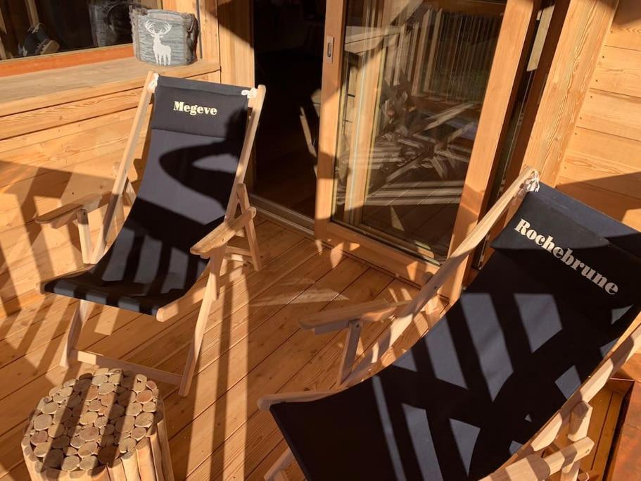 a couple of chairs sitting on a porch at Appartement dans chalet de luxe Megève in Megève