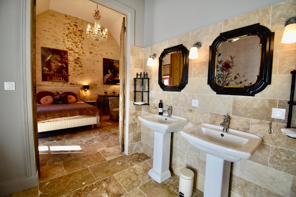 a bathroom with two sinks and a bedroom at La Maison d'Horbé in La Perrière