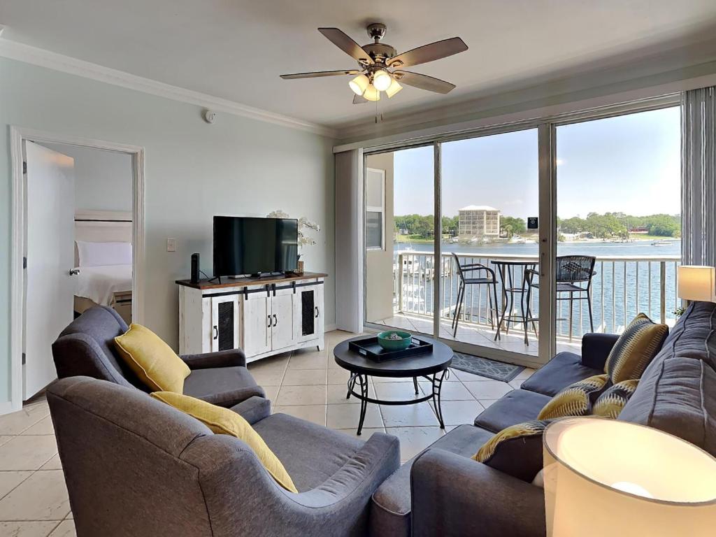 sala de estar con sofá y TV en Palm Court Yacht Club #308, en Fort Walton Beach