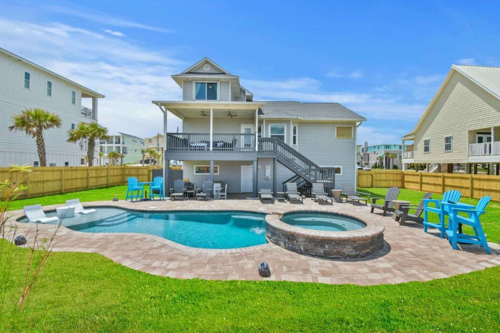a backyard with a pool and chairs and a house at Gratitude Island in Navarre