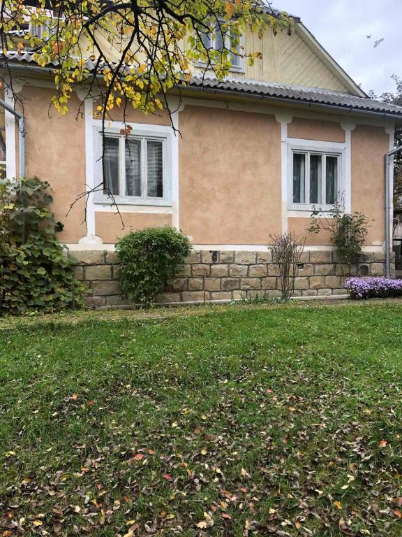 una casa con un muro de piedra delante de un patio en Hudozhnyk, en Yaremche