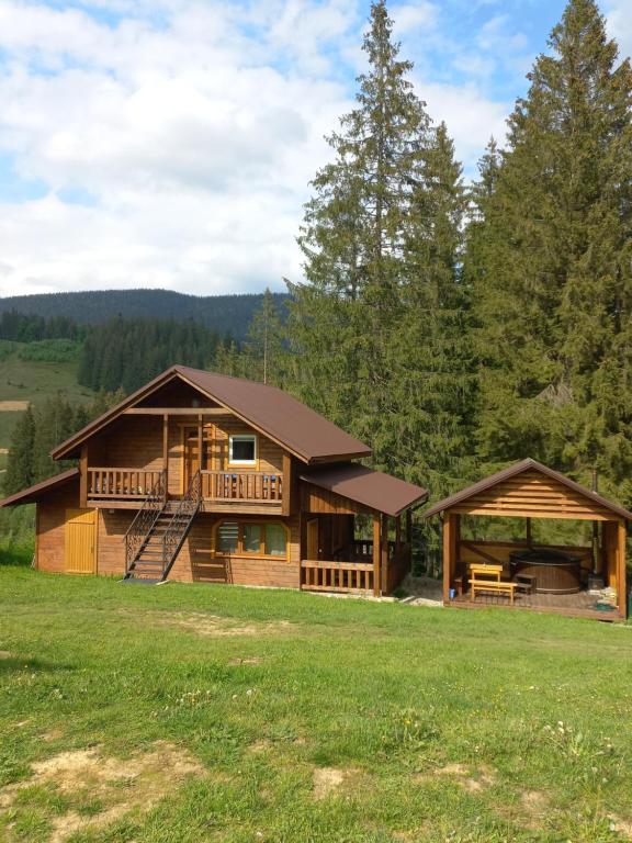 a log home with a deck and a porch at На горі in Vorokhta