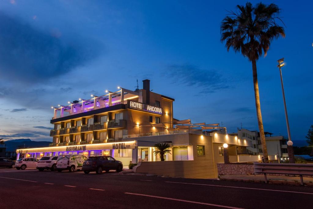 un hotel con coches estacionados frente a un edificio en Hotel Ancora en Pontecagnano