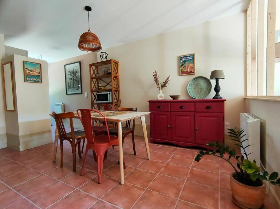Dolce Vita en Provence في شاتورينارد: غرفة طعام مع طاولة وكراسي وخزانة حمراء