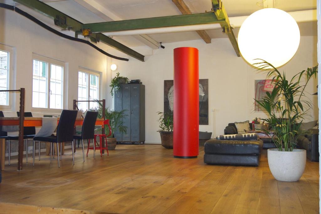 a living room with a table and a red pole at Loft63 am Bodensee in Arbon