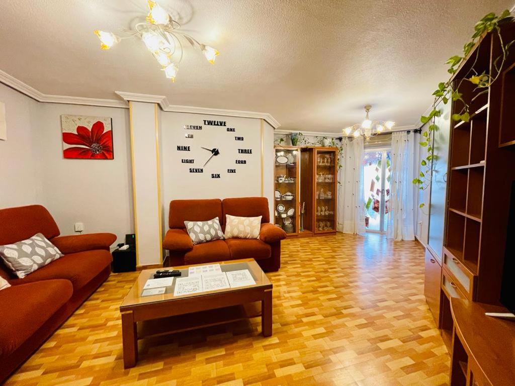 a living room with two couches and a clock on the wall at MERIDA LÚDICA centro a 5 min , parking privado en el edificio in Mérida