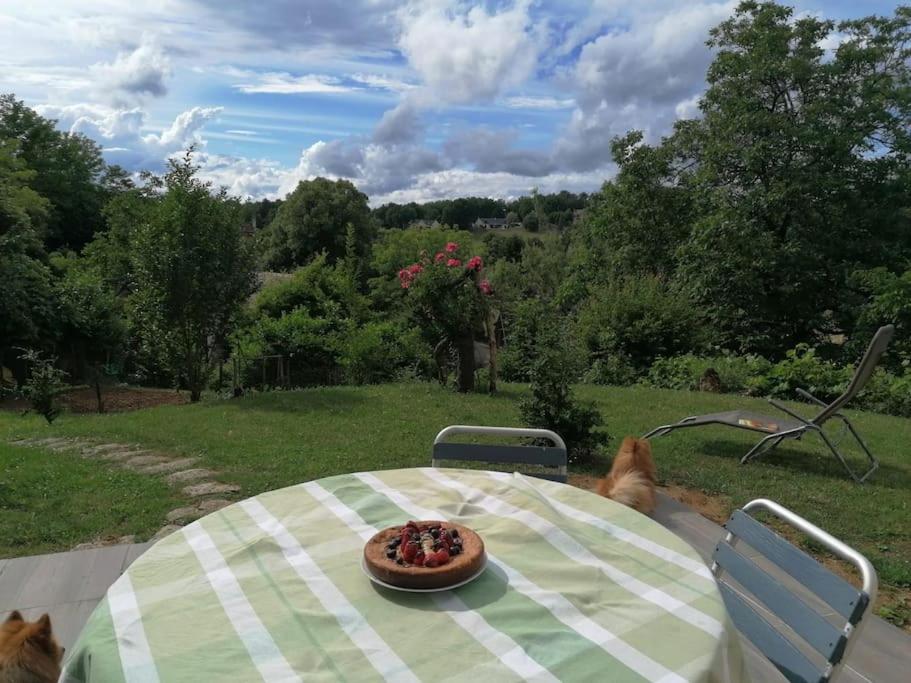 ein Teller mit Essen auf einem Tisch mit zwei Hunden in der Unterkunft Magnifique maison avec vue panoramique in Carlux