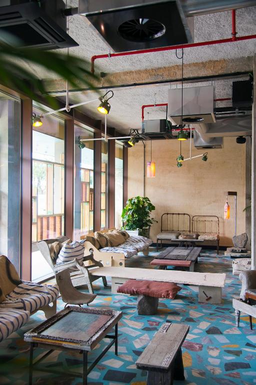 A large, eclectic lounge filled with sofas, low tables and colourful textiles.