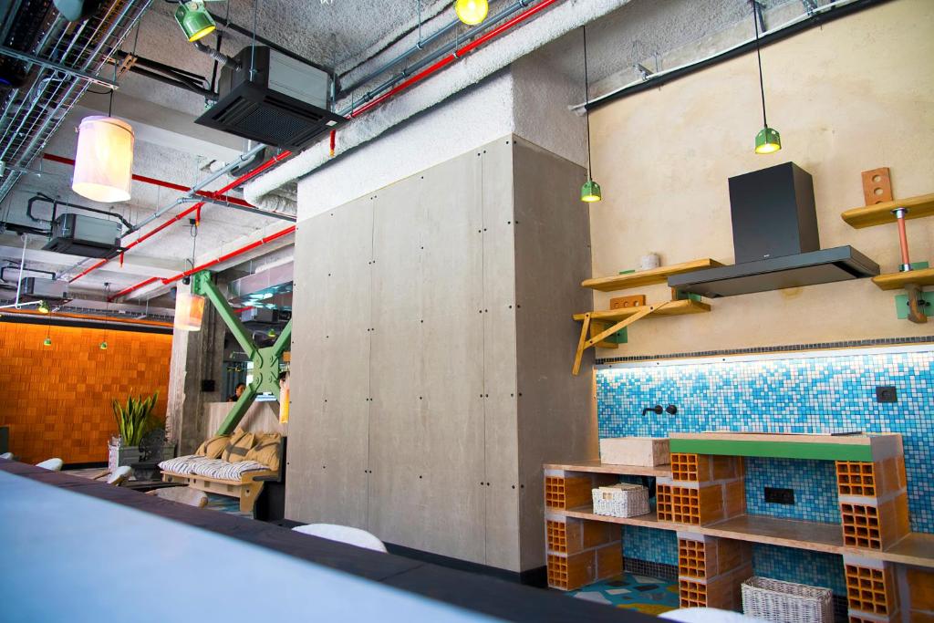 A colorful communal interior with a tiled fireplace wall and shelves.