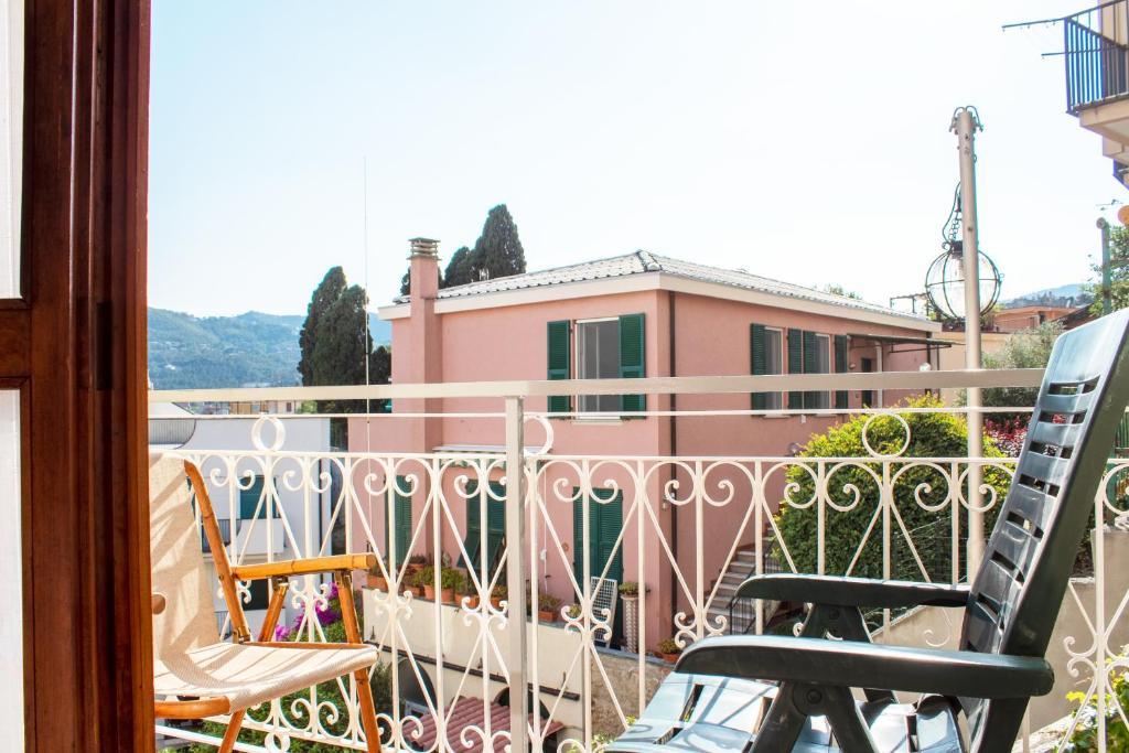 uma varanda com cadeiras e uma casa rosa em [300 metri dal mare] Relax con aria condizionata em Spotorno
