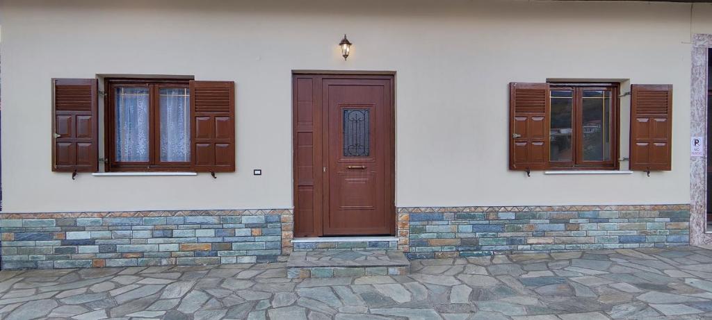 duas portas e janelas do lado de um edifício em Theofania's Marble House Meteora em Kastrákion