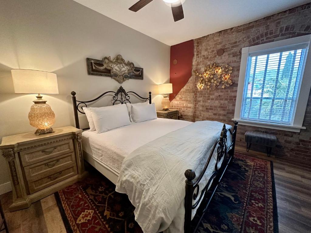 a bedroom with a bed and a brick wall at Bisbee Brownstone Suites in Bisbee