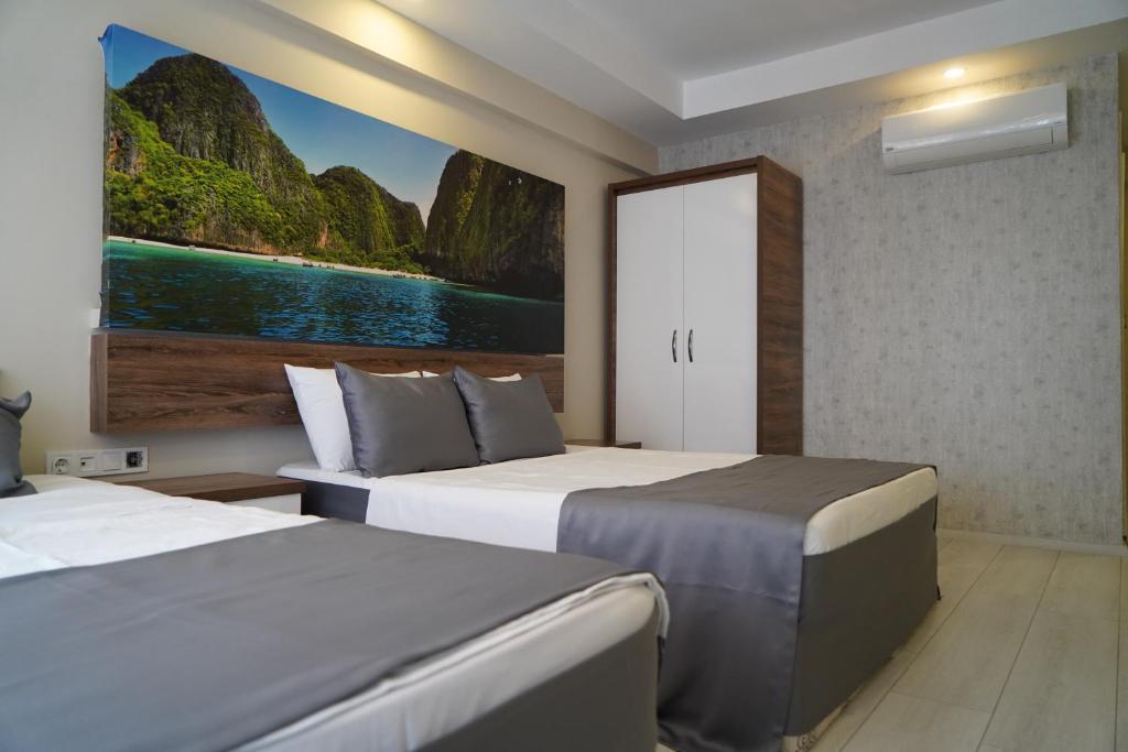 アンタルヤにあるAntalya Dreamsのベッド2台が備わる客室で、壁には絵画が飾られています。