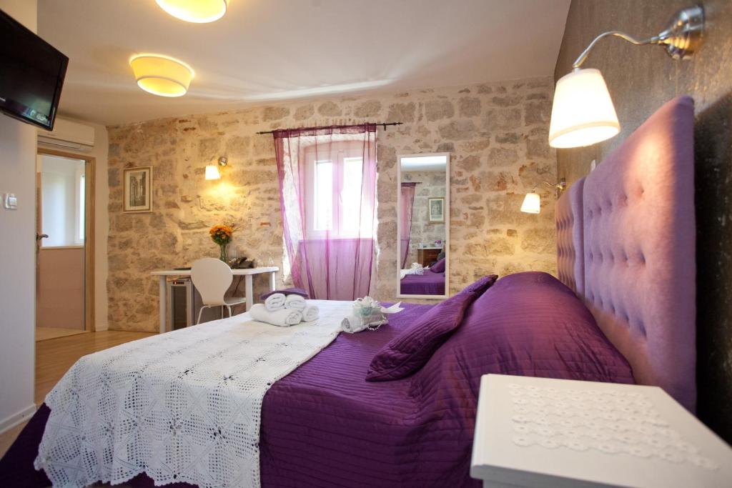 a bedroom with a purple bed and a window at Bed & Breakfast Vila Baguc in Split