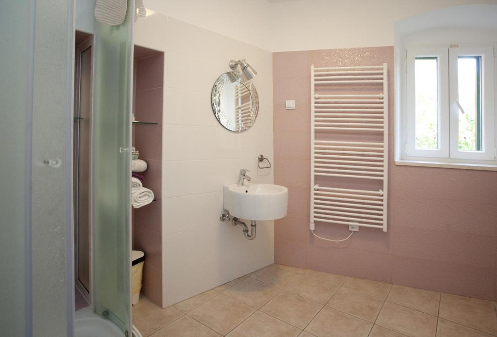 a bathroom with a sink and a toilet and a window at Bed & Breakfast Vila Baguc in Split