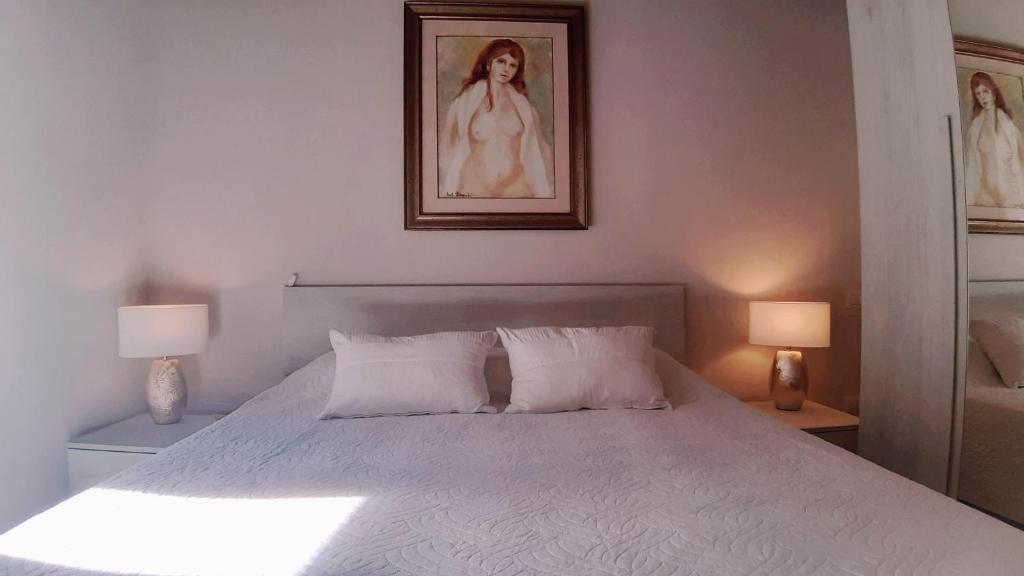 a bedroom with a white bed with two lamps at Civico in Gubbio