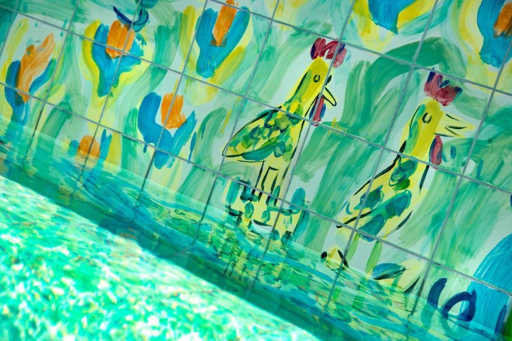 A close-up of the pool water beside hand-painted bird and floral tiles.