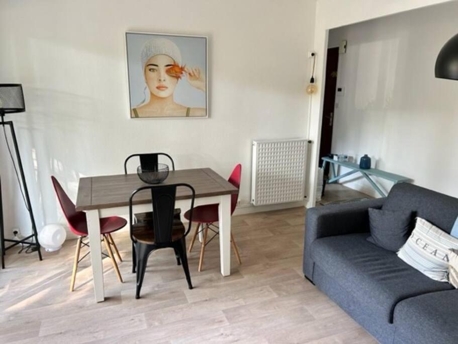 a living room with a table and a couch at Appartement avec Wifi La Baule Les Pins in La Baule