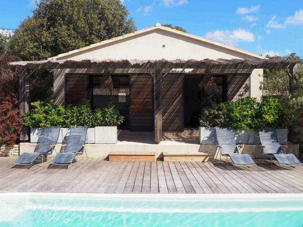 un grupo de sillas sentadas en una terraza junto a una piscina en songes d été2, en Bonifacio