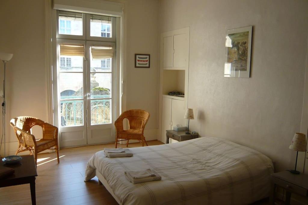 um quarto com uma cama, 2 cadeiras e uma janela em Très lumineux, au coeur de la vieille ville, 86 m² em La Rochelle