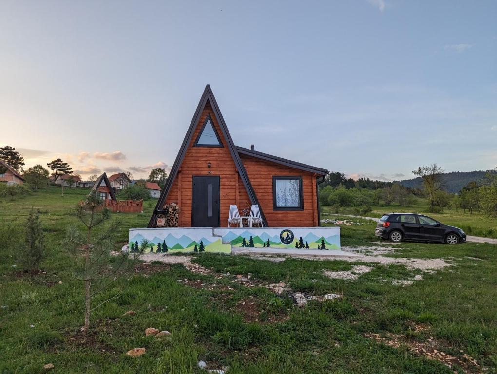 a small house with a car parked in front of it at AA Pine vikendica za izdavanje u srcu Zapadne Srbije in Nova Varoš
