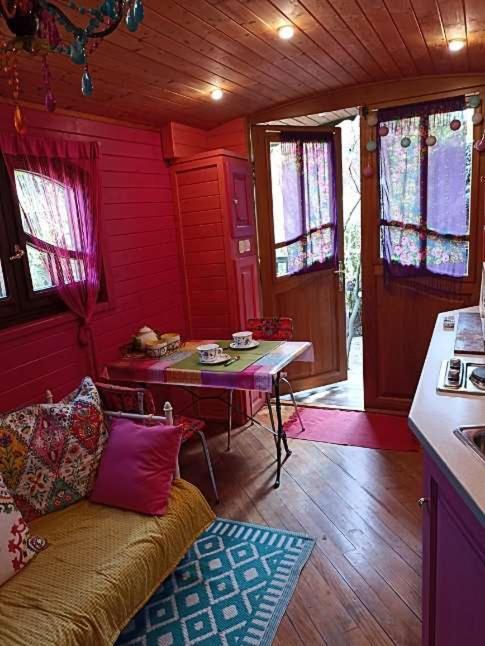 une chambre avec un canapé et une table dans une cuisine dans l'établissement Roulotte des Alpilles, à Maussane-les-Alpilles