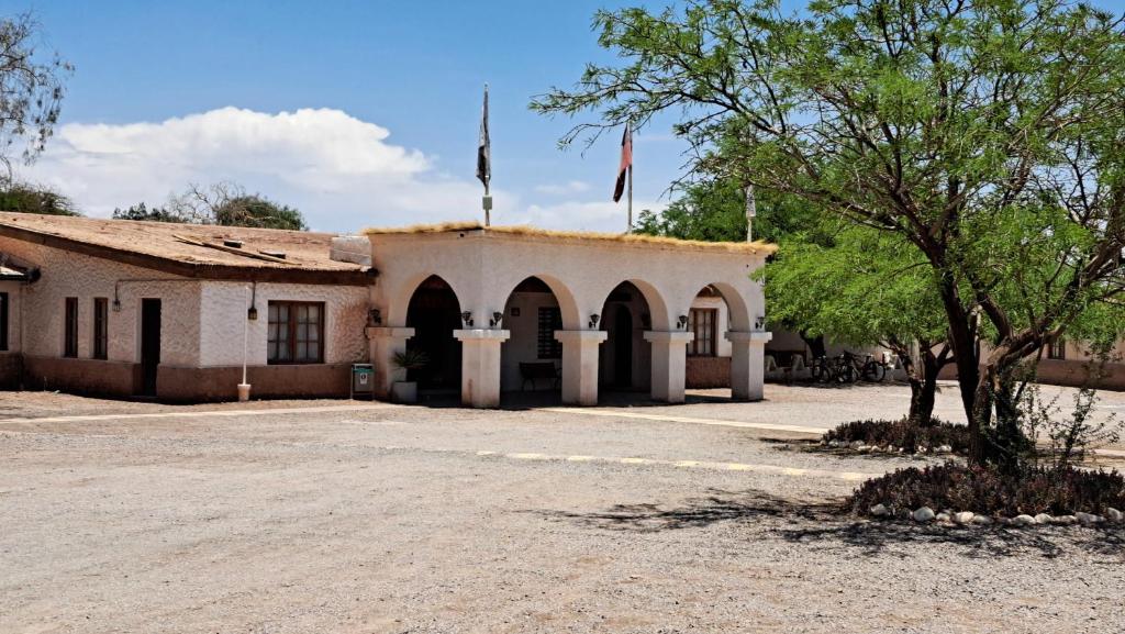 um edifício com duas bandeiras em cima em Hotel Diego de Almagro San Pedro De Atacama em San Pedro de Atacama