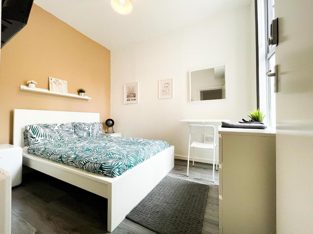 a small bedroom with a bed and a desk at Charming Retreat in the heart of the City in Liverpool