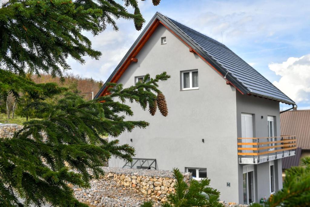 a white house with a black roof at Kuća za odmor Bubamara in Ravna Gora