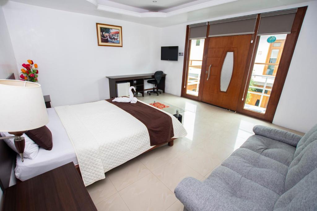 um quarto com uma cama e um sofá em Blue Marlin Hotel em Puerto Baquerizo Moreno