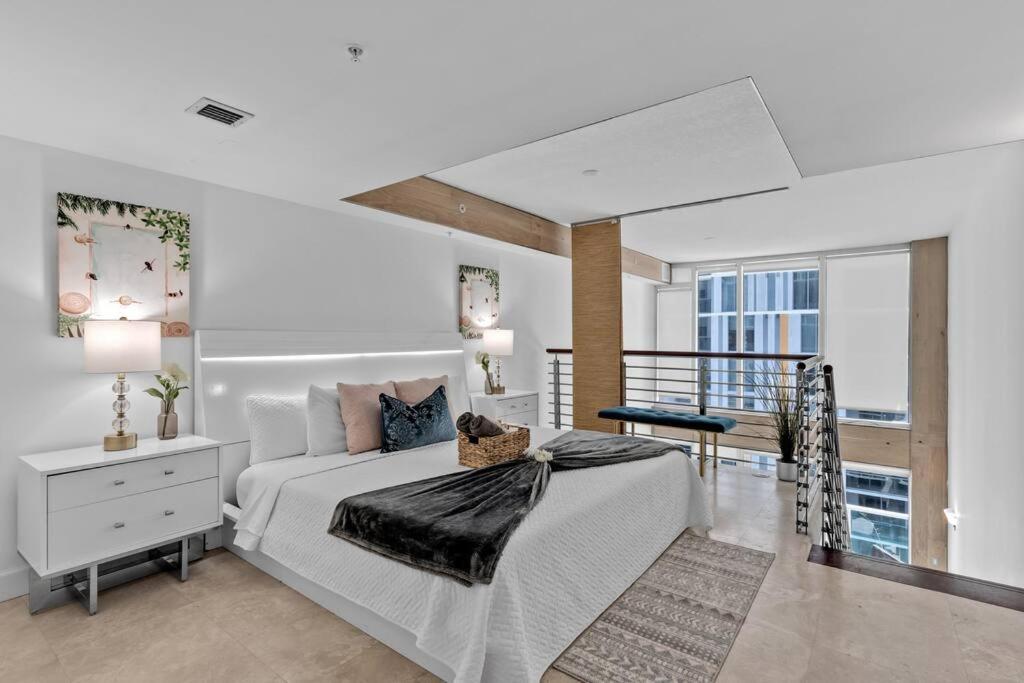 a white bedroom with a bed and a balcony at Elegant king bedroom Loft in Miami